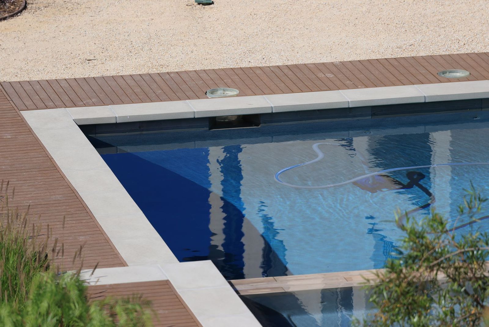 Schwimmbecken mit Holzdeck und klarem blauem Wasser
